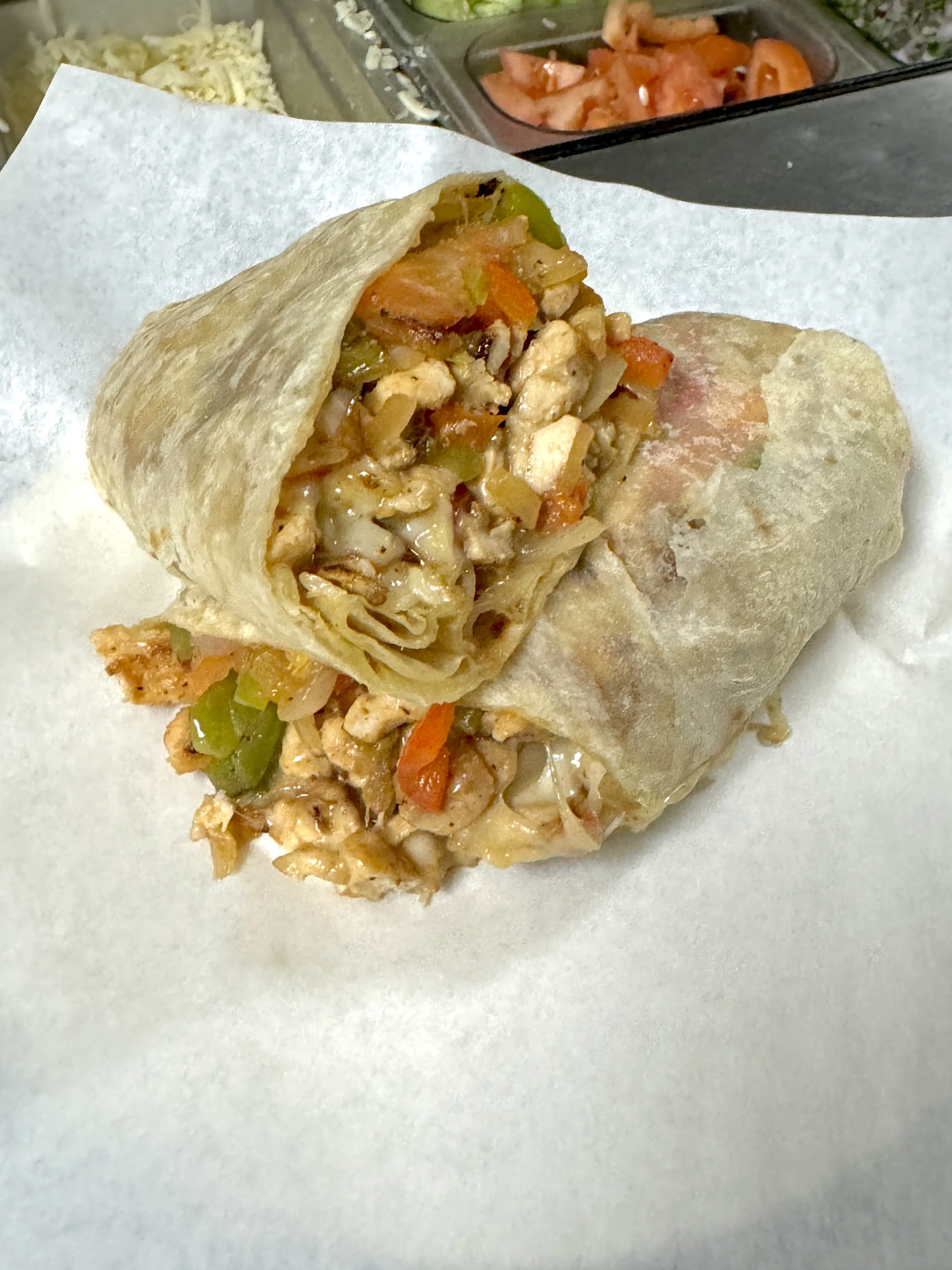 Wouth watering chicken burrito cut in half exposing all its rich colors and juiciness